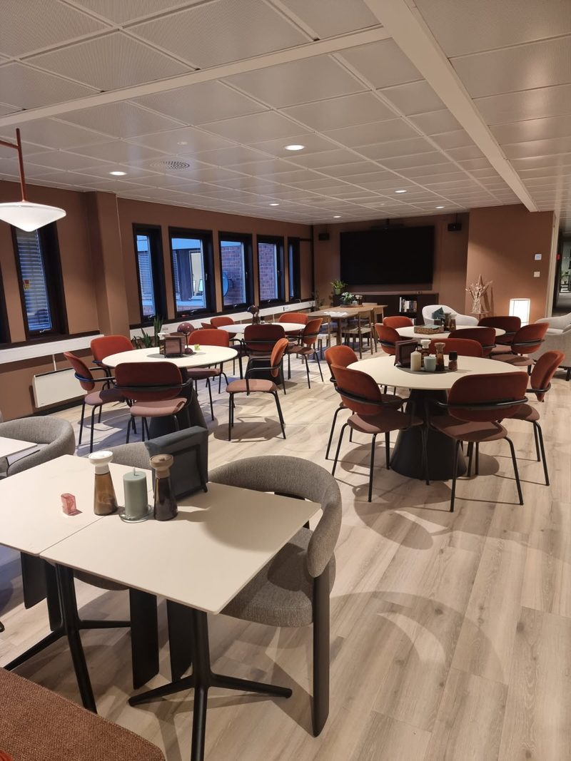 Lys lounge med kafébord og stoler i lokalene på Nesbru